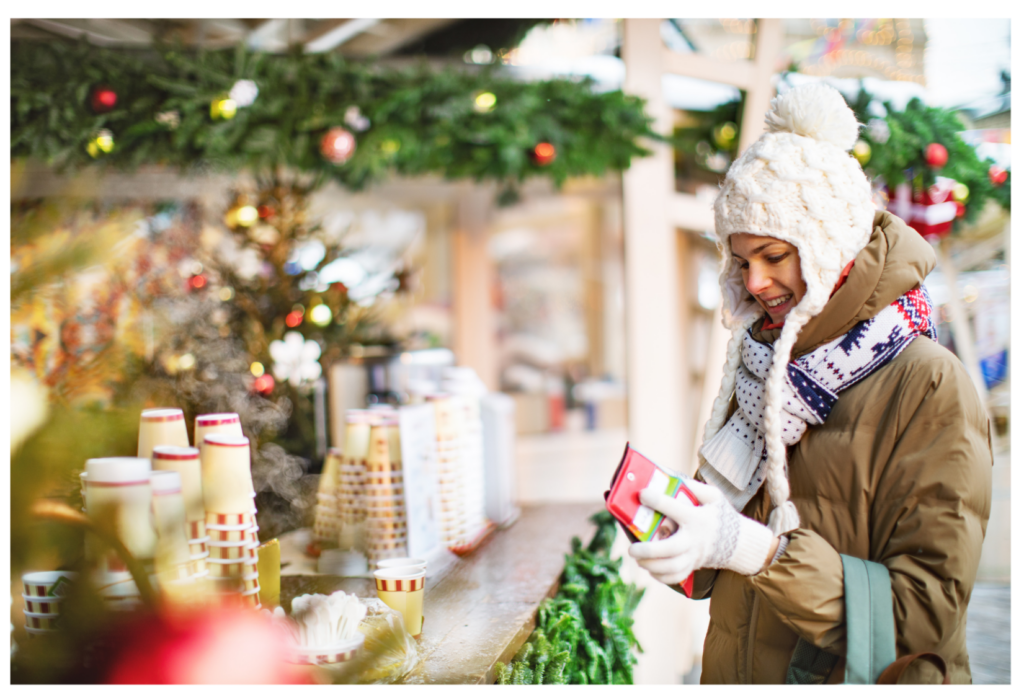 Frau beim Weihnachtsbummel an einem Verkaufsstand.