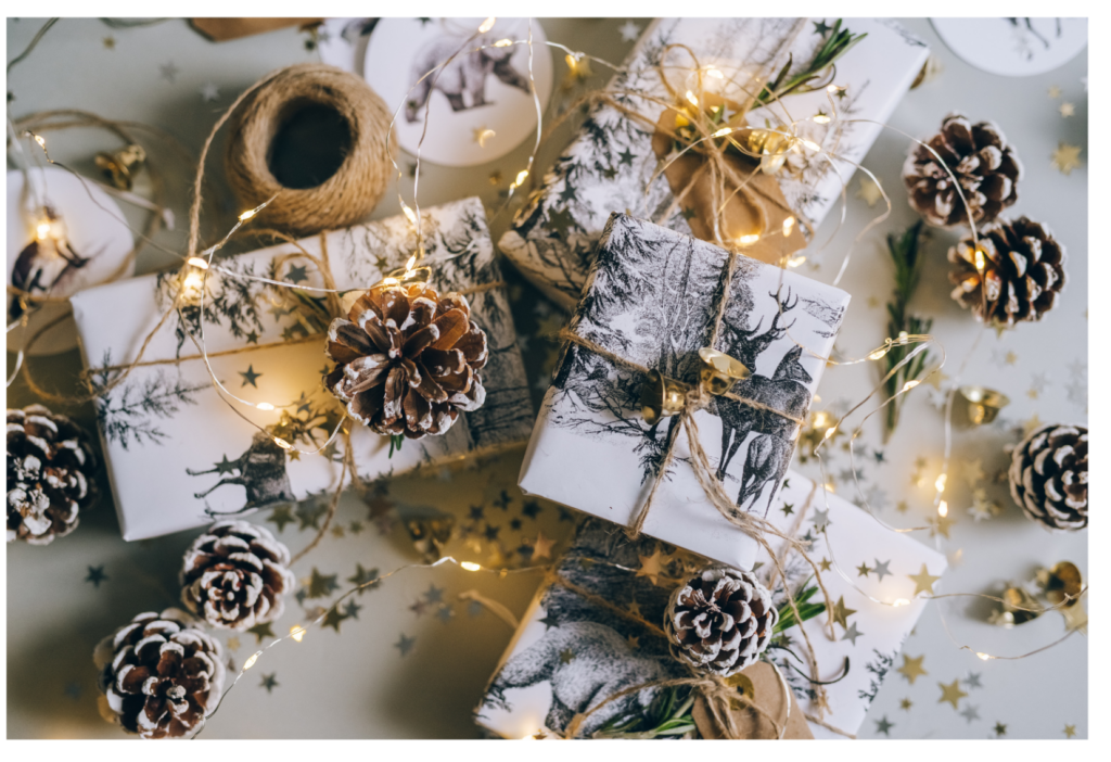 WeihnachtenInstagramMarketing_StadtLandMaketing (7) schön verpackte Weihnachtsgeschenke: weißes Papier, Tannzweige, Lichterkette.