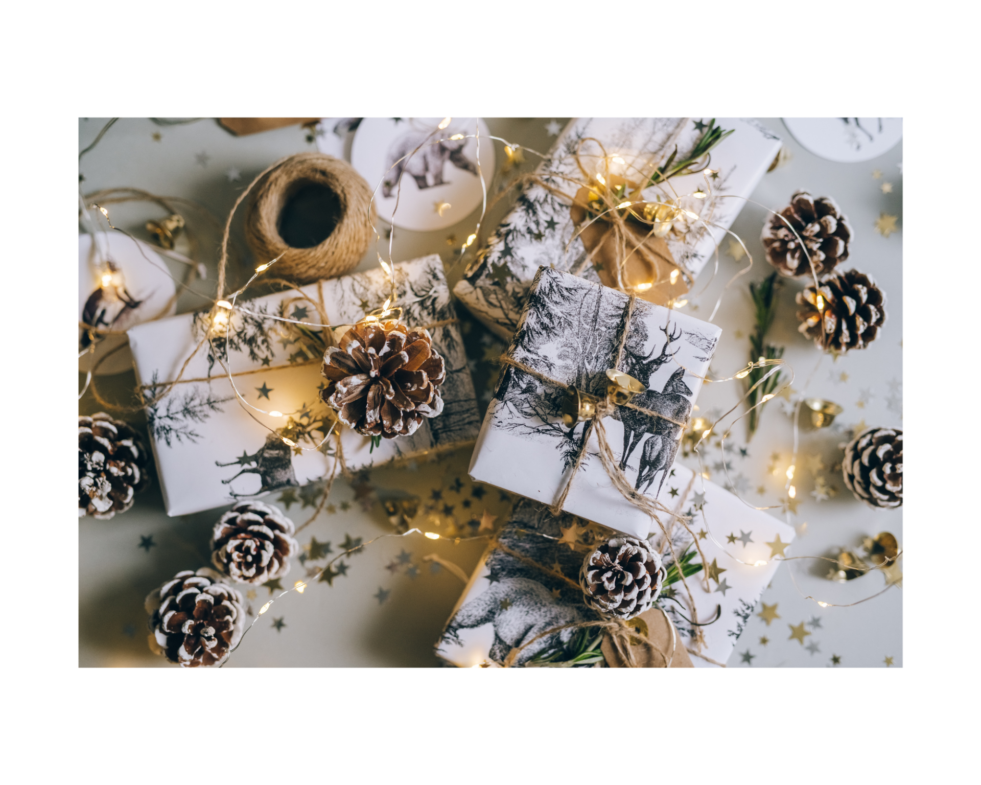 schön verpackte Weihnachtsgeschenke: weißes Papier, Tannzweige, Lichterkette.